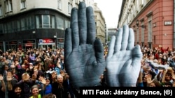 Tüntetés a kormány civilpolitikája ellen a Norvég Alap kapcsán 2014-ben. Kartonpapír kezekkel jelezték: stop a civilek elleni támadásoknak.