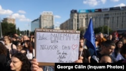 Participanții la miting afișează pancarte de susținere a lui Nicușor Dan.