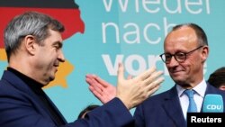 Лидерите на ХДС Фридрих Мерц (вдясно) и на ХСС Маркус Зьодер се поздравяват след победата на тяхната коалиция на изборите в неделя, 23 февруари 2025 г.