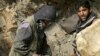 Afghan miners drill into rock in a makeshift emerald mine (file photo).