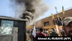 Pripadnici iračke paravojne šiitske milicije Kataeb Hezbolah i demonstranti, tokom napada na Ambasadu SAD u Bagdadu, 31. decembar 2019. 