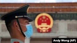 Policajac koji nosi masku prije završnog zasjedanja Kineske narodne političke konsultativne konferencije (CPPCC) u Velikoj dvorani naroda u Pekingu, srijeda, 27. maj 2020. 