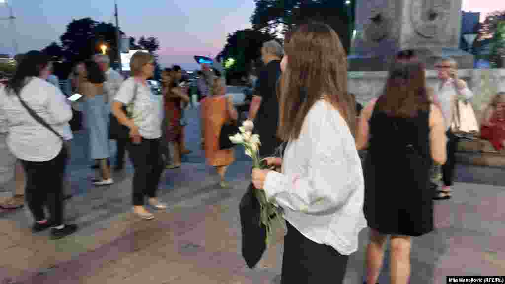 Detalj kod Terazijske česme u Beogradu, 12. avgust 2025. Devojka u ruci drži cveće kojim želi da oda počast Gabi Novak.