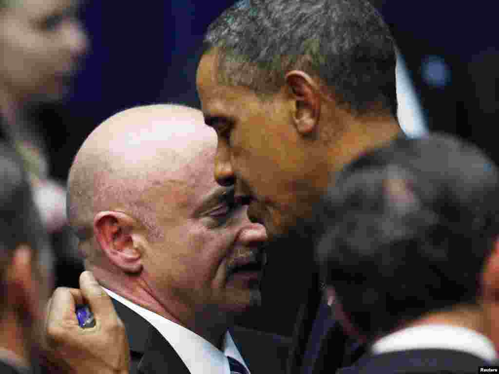 Американскиот претседател, Барак Обама, се прегрнува со шатл командантот на НАСА, Марк Кели, сопруг на американската конгресменка, Габриела Гифорд, откако Гифорд беше сериозно повредена во престрелка, во Туксон, Аризона, во којашто загинаа шест лица.<br /