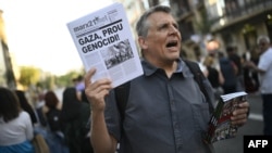 Demonstrant drži papire na kojima piše "Gaza, zaustavite genocid" tokom protesta protiv rata na palestinskim teritorijama Gaze, 13. juna 2024. godine u Barceloni.