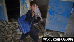 FILE: An Afghan schoolboy carries his backpack at a school near the site of a Taliban car bomb attack in Kabul in July.