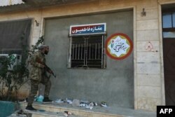 Повстанец антиасадовской коалиции инспектирует захваченную базу проиранских шиитских боевиков из группы "Бригады Фатимиюн" в городе Хан-Шейхун. Сирийская провинция Идлиб, 1 декабря 2024 года