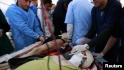 Lekari i medicinsko osoblje pomažu povređenima Chrisu Hondrosu iz Gettya (prednji plan) i fotoreporteru Timu Hetheringtonu (u pozadini), bolnica u Misrati 20. april 2011.