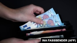 Një person duke nxjerrë para nga portofoli. Fotografi ilustruese.