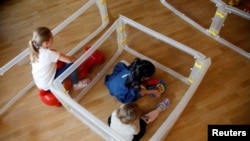 Djeca se igraju u jaslicama tokom demonstracije za upotrebe štitnika od širenja korona virusa. Fotografija je zabilježena u njemačkom gradu Velbertu, 8. april 2021.