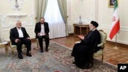 Președintele Ebrahim Raisi (D) discută cu liderul grupării militante palestiniene Hamas, Ismail Haniyeh (S) în timpul întâlnirii de la Teheran. 20 iunie 2023.