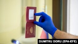 Një burrë duke e treguar pasaportën e tij në Ambasadën e Rusisë në Moldavi.
