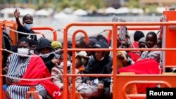 Migránsok a spanyol parti őrség hajója fedélzetén a Kanári-szigetek Arguineguín kikötőjében 2023. június 3-án