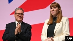 Prim-ministrul britanic Keir Starmer (stânga) o aplaudă pe viceprim-ministrul și secretarul de stat pentru Locuințe, Comunități și Administrație Locală Angela Rayner (dreapta) pe scenă, în prima zi completă a conferinței anuale a Partidului Laburist(arhivă).