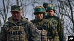 Украински войници от 28-а бригада вървят по фронтовата линия край Бахмут, 27 март.