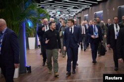 Președintele Ucrainei, Volodimir Zelenski, discută cu Emmanuel Macron, președintele Franței, în timp ce se îndreaptă spre o întâlnire în cadrul Summitului Comunității Politice Europene de la Puskas Arena, Budapesta, 7 noiembrie 2024.