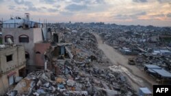 Палестинско семејство во својата уништена куќа среде урнатините од зградите во Беит Лахиа во северниот дел на Појасот Газа на 4 март 2025 година, за време на муслиманскиот свет пост месец Рамазан.