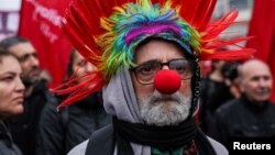 Човек носи клоунски нос и перука по време на шествие по случай 1 май в Кадъкьой, Истанбул, Турция. Над 400 души са били задържани в Турция от полицията заради участие в демонстрации за честване на 1 май, Ден на труда и солидарността, съобщиха турските медии.