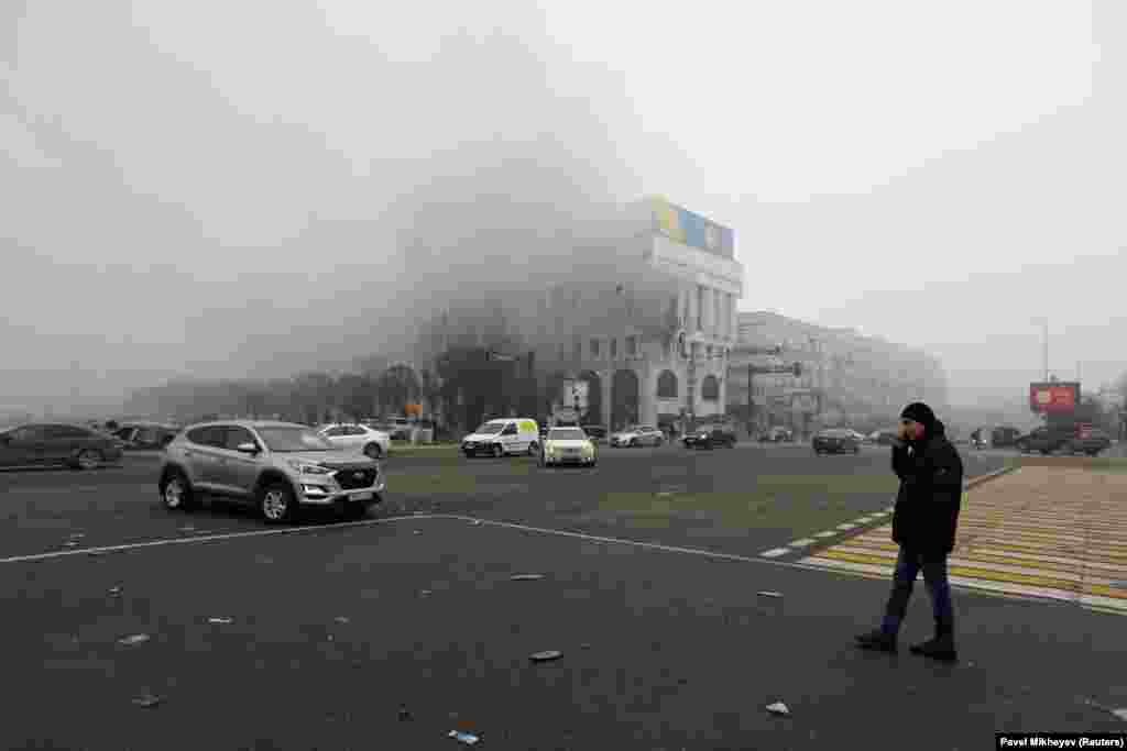 Еден човек гледа како гори канцеларијата на Казахстанската државна телевизија во Алмати на 6 јануари.