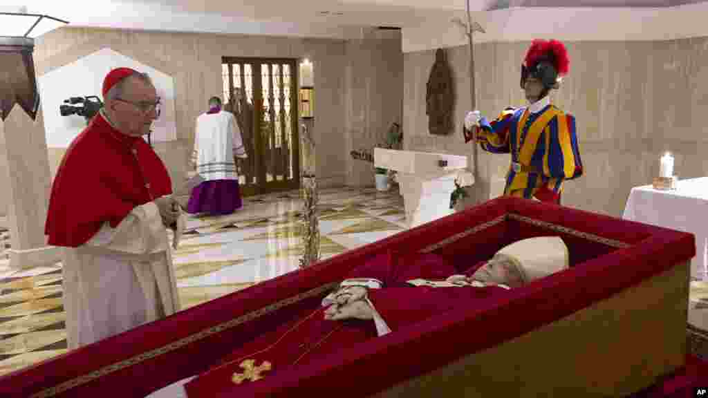 Državni sekretar Vatikana, kardinal Pietro Parolin, lijevo, moli se ispred tijela pape Franje, položenog u kovčeg, u njegovoj privatnoj kapeli u Vatikanu