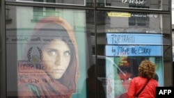 Франција - жена гледа во постерот нa американскиот фотограф Стив Мекгури - 05 Jули 2007