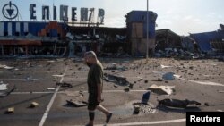 Un bărbat trece pe lângă un centru comercial lovit de un atac rusesc în orașul Kameanske din regiunea ucraineană Dnipropetrovsk, pe 26 iulie.