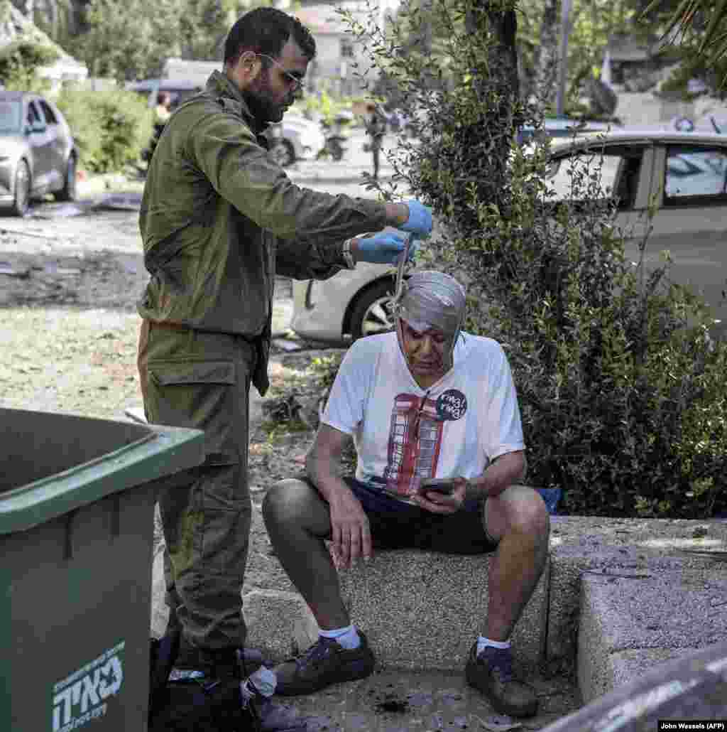 An injured man is treated at the site of an Iranian missile strike that impacted just south of Tel Aviv on June 14.