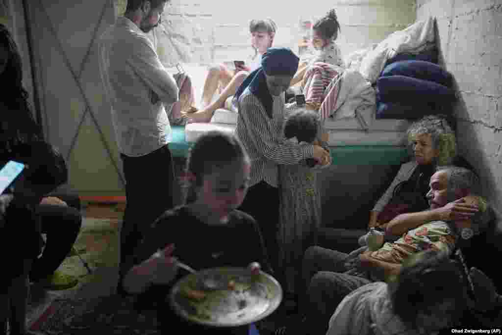 Izraelitë duke u strehuar në një bodrum në Jerusalem, mes zhurmës së sirenave pas raketave të lëshuara nga Irani, më 15 qershor.