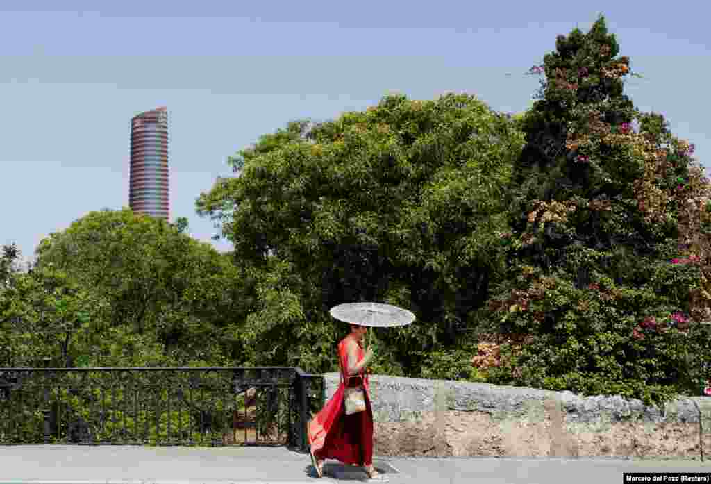 Žena se štiti od sunca kišobranom u Sevilji, Španija, 29. juna.