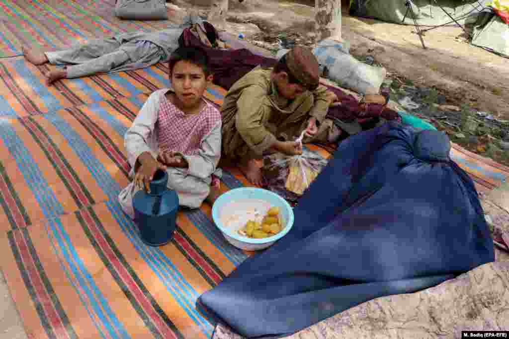 A woman sleeps in her burqa after she and her family were forced from their homes in Kandahar on August 4.