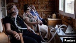 Жени вдишват въздух от кошери с надеждата да се възстановят от заболявания в помещение на пчеларя Хюсеин Джейлан в Карабурун, Измир, Турция, 22 май 2025 г.