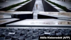 Mladi posjetilac šeta oko spomenika Trianonu, u blizini zgrade parlamenta u Budimpešti u januaru 2021.