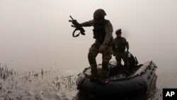 Украински войник скача от лодка на брега на река Днепър на фронтовата линия край Херсон на 15 октомври.