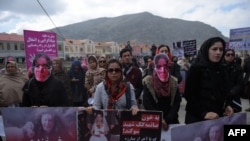 Afghan activists march before artists performed a play depicting the 2015 lynching of Afghan woman Farkhunda Malikzada in Kabul on March 17, 2016.