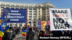Susținători ai politicianului pro-rus Călin Georgescu afișează bannere la manifestația din Piața Constituției, București, 22 februarie 2025.