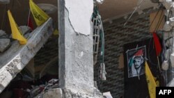 Simboluri ale mișcării palestiniene Fatah, cu fotografia liderului ei istoric Yasser Arafat, la 29 aprilie 2024, într-o clădire distrusă de bombardamentele israeliene din Fâșia Gaza. Fatah nu mai are aproape nicio influență în Gaza, unde Hamas a preluat controlul în 2007.