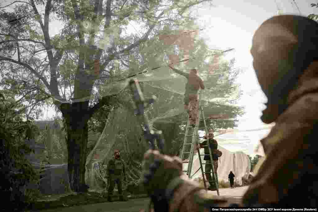 Украинские военнослужащие устанавливают сетки для защиты от беспилотников над дорогой, Донецкая область, Украина, 19 сентября 2025 года. Oleg Petrasiuk 