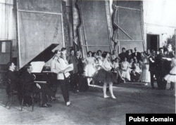 Репетиция балета Игоря Стравинского "Жар-птица". У рояля справа – Стравинский, стоит облокотившись на рояль Михаил Фокин, в центре – Тамара Карсавина. 1910.