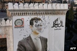 Portret Bašara el-Asada izrešetan mecima u gradu Hama, 6. decembar 2024.