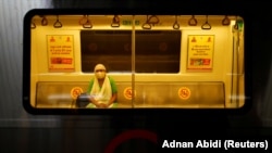 Илустрација - Индијка со заштитна маска за лице во метро