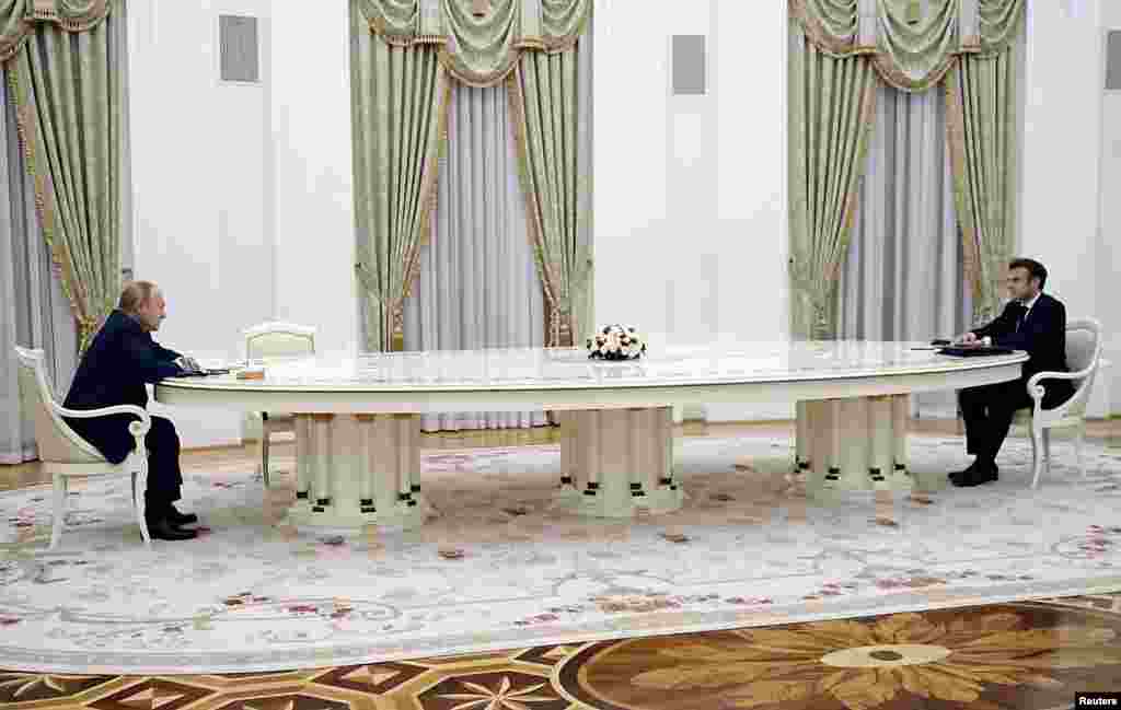 Președintele rus Vladimir Putin (stânga) găzduiește o întâlnire la Moscova cu președintele francez Emmanuel Macron, pe 7 februarie, pentru a discuta despre modalitățile de dezescaladare a crizei provocate de masarea de către Kremlin a peste 100.00 de soldați și echipamente în apropierea frontierei ucrainene. Masa extraordinar de lungă și distanța dintre cei doi președinți au generat o multitudine de meme-uri în Rusia.