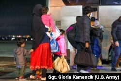 Policija Kosova i Kosovske bezbednosne snage pomažu Avganistancima da se ukrcaju u autobus na aerodromu u Prištini na putu do kampa Lija, 16. oktobra 2021.