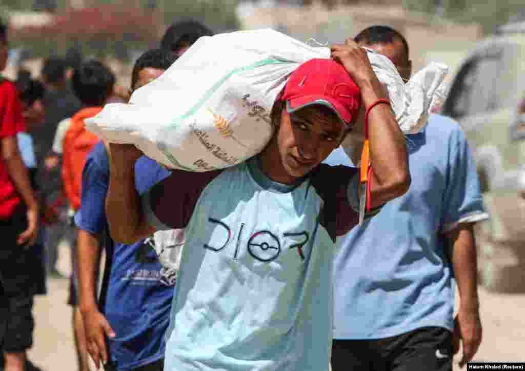 Palestinac nosi vreću s pomoći koja je stigla padobranom, 31. jula.