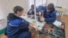 Elevi ai unei școli profesionale din Chișinău, specializați în meseria de lăcătuș-electrician pentru repararea utilajului electric, în timpul orelor practice.