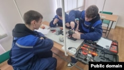 Elevi ai unei școli profesionale din Chișinău, specializați în meseria de lăcătuș-electrician pentru repararea utilajului electric, în timpul orelor practice.