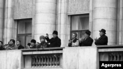 Nicolae Ceaușescu, oficial președinte al Republicii Socialiste România și secretar general al Partidului Comunist Român, Elena Ceaușescu, premierul C. Dăscălescu și alți demnitari, pe 21 Decembrie, în jur de ora 11, cu puține minute înainte de startul Revoluției la București.