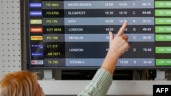 Prije nekoliko sedmica Alina je bila u Ukrajini, i vratila se, kako kaže, s "grčem u želucu zbog zebnje da će biti rata" (na fotografiji žena prati podatke o letu za Kijev sa jednog od svjetskih aerodroma)