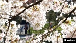 Ljudi na propisanoj distanci u briselskom parku pored Evropskog parlamenta, 26. mart, 2020. 