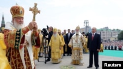 Vladimir Putin, predsjednik Rusije, posmatra liturgiju koju služi patrijarh Ruske pravoslavne crkve Kiril na ceremoniji upriličenoj u Moskvi 28. jula 2018. povodom 1030-te godišnjice pravoslavlja u Rusiji. Kiril je podržao invaziju koju su ruske snage sprovele nad Ukrajinom počevši sa 24. februarom 2022.