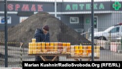 Un apicultor vinde miere, ceară de albine și alte produse apicole în punctul de control.